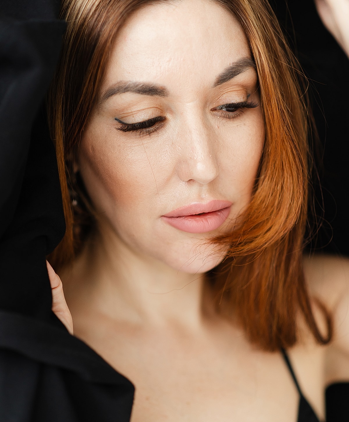 Close-up of woman with auburn hair and makeup.