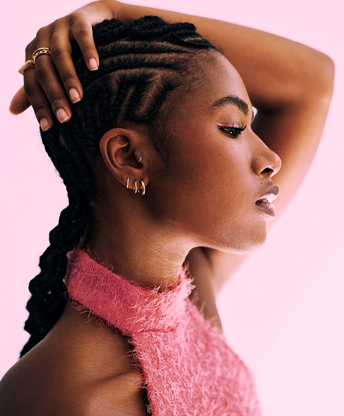 Profile of woman with braided hair and pink top.