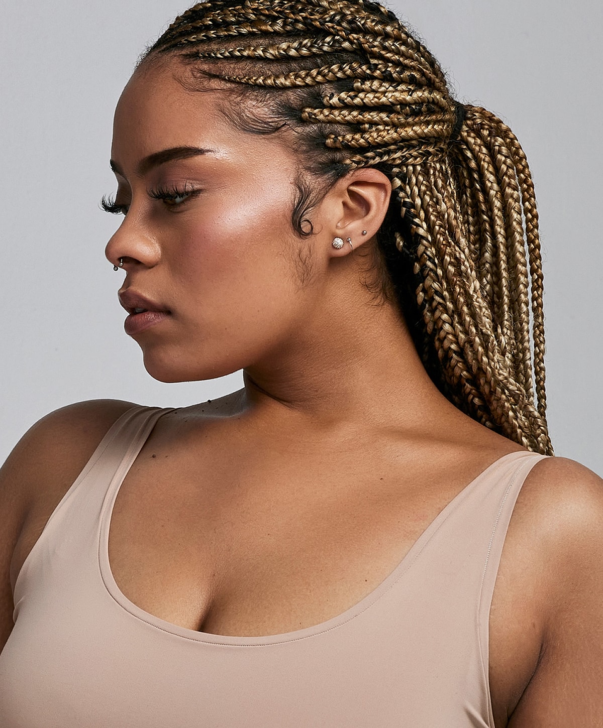 Woman with braided hair and a neutral expression.