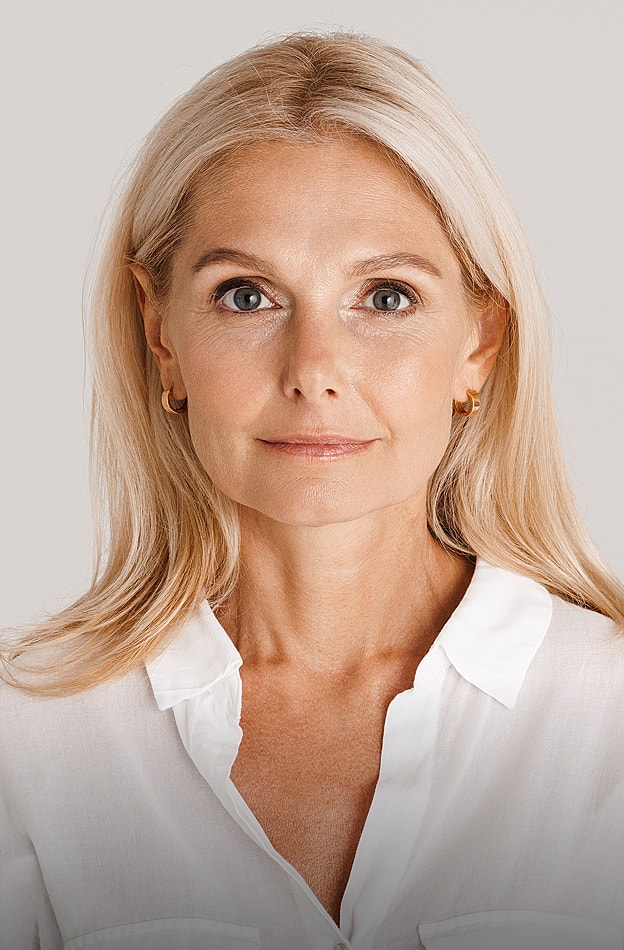 Woman with blonde hair, neutral expression, white shirt.