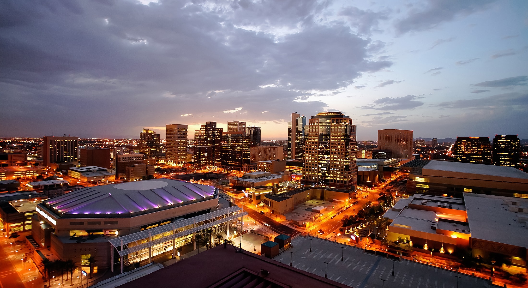 City skyline at dusk with illuminated buildings.