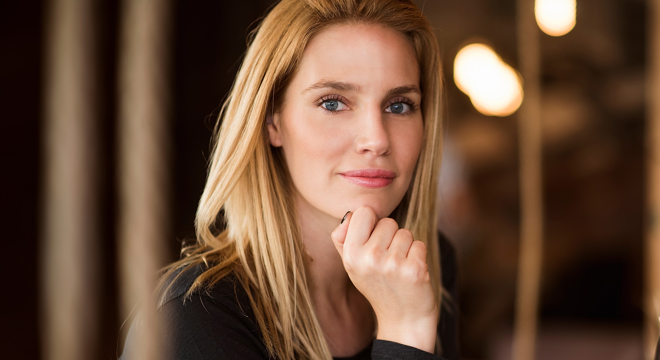 Woman with long blonde hair, deep in thought.