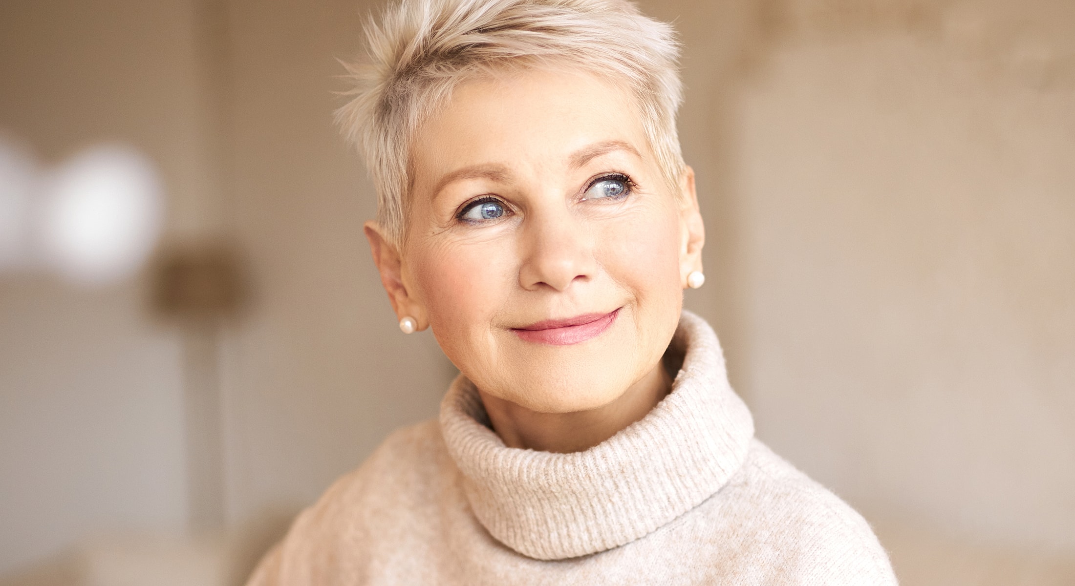 Smiling older woman with short blonde hair.