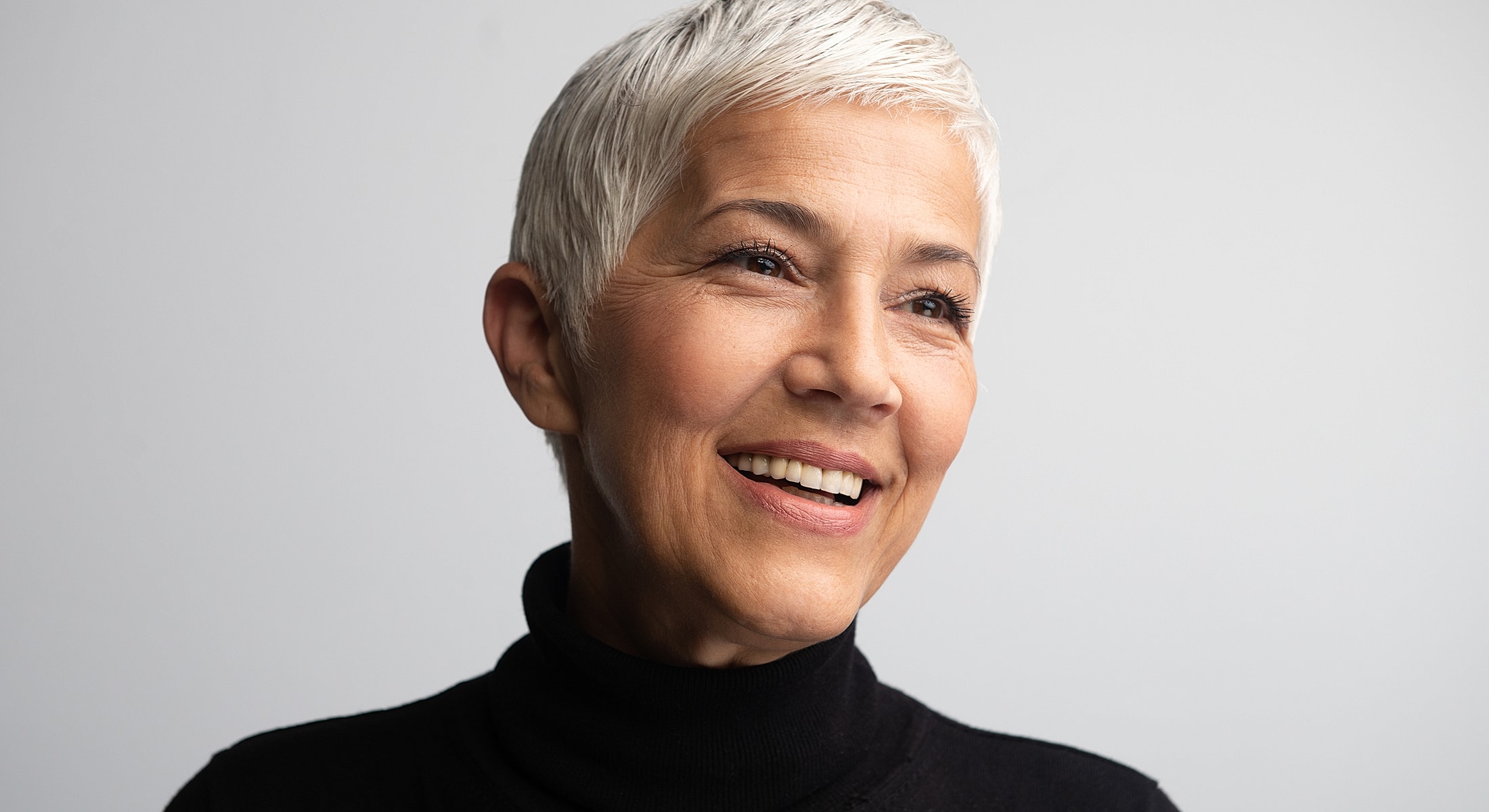 Smiling older woman with short, gray hair.